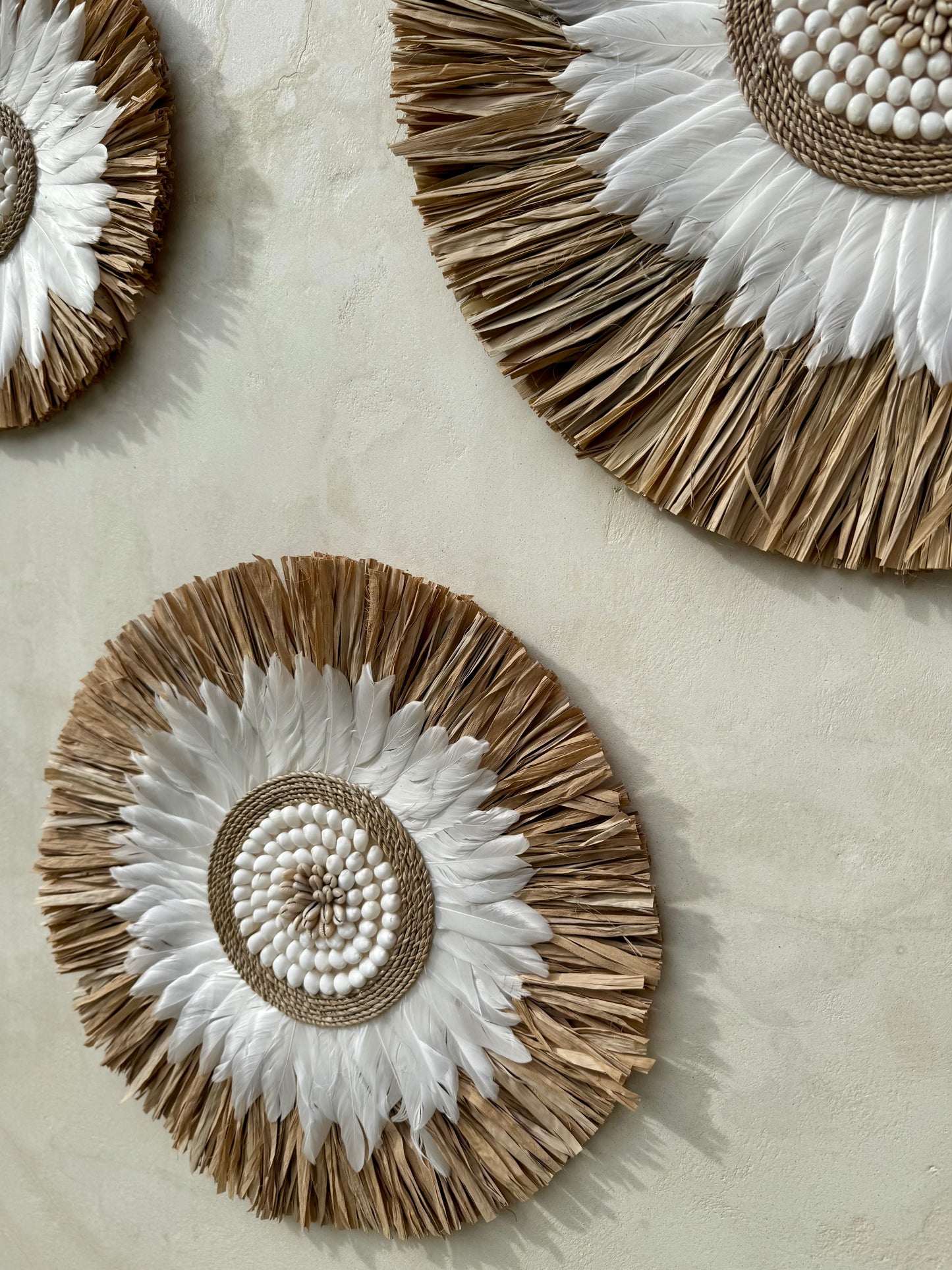 Décoration murale ronde bohème en coquillages et plumes – décoration artisanale de Bali