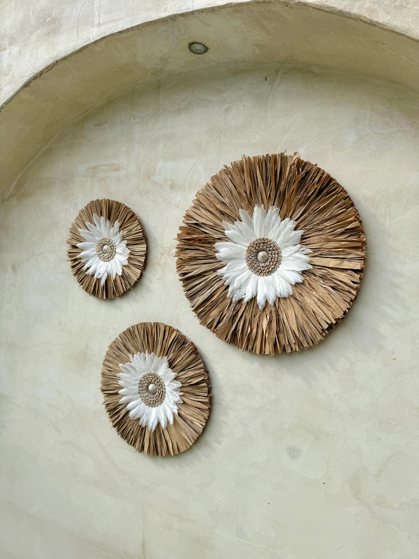 Décoration murale ronde bohème en coquillages et plumes blanches – création artisanale de Bali