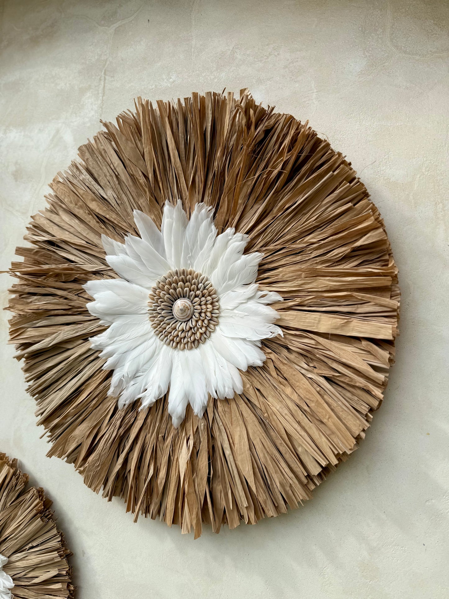 Décoration murale ronde bohème en coquillages et plumes blanches – création artisanale de Bali