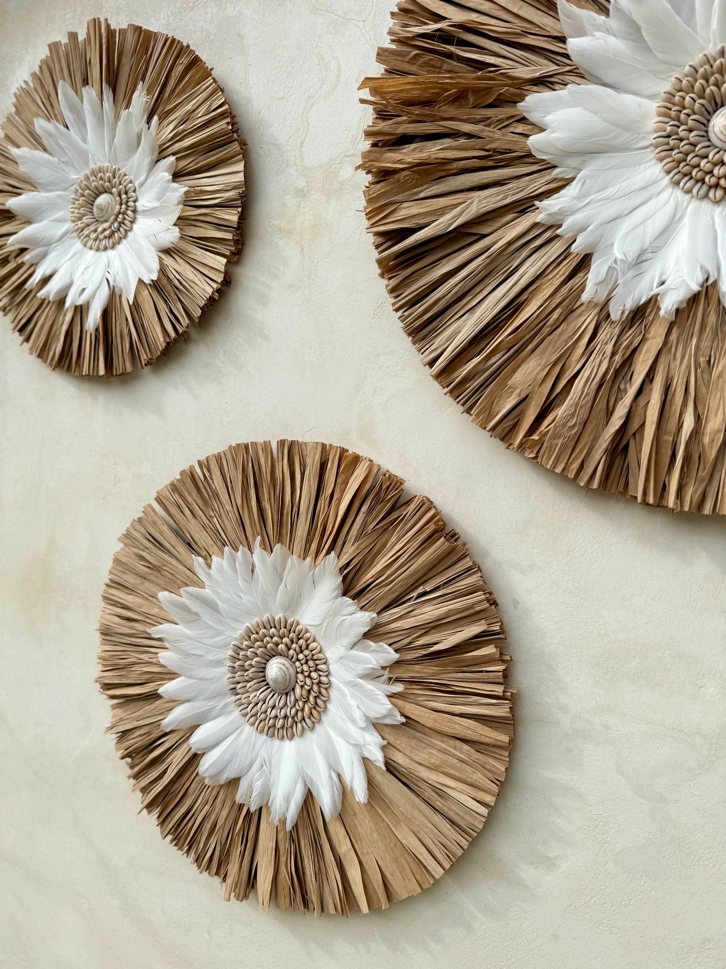 Décoration murale ronde bohème en coquillages et plumes blanches – création artisanale de Bali