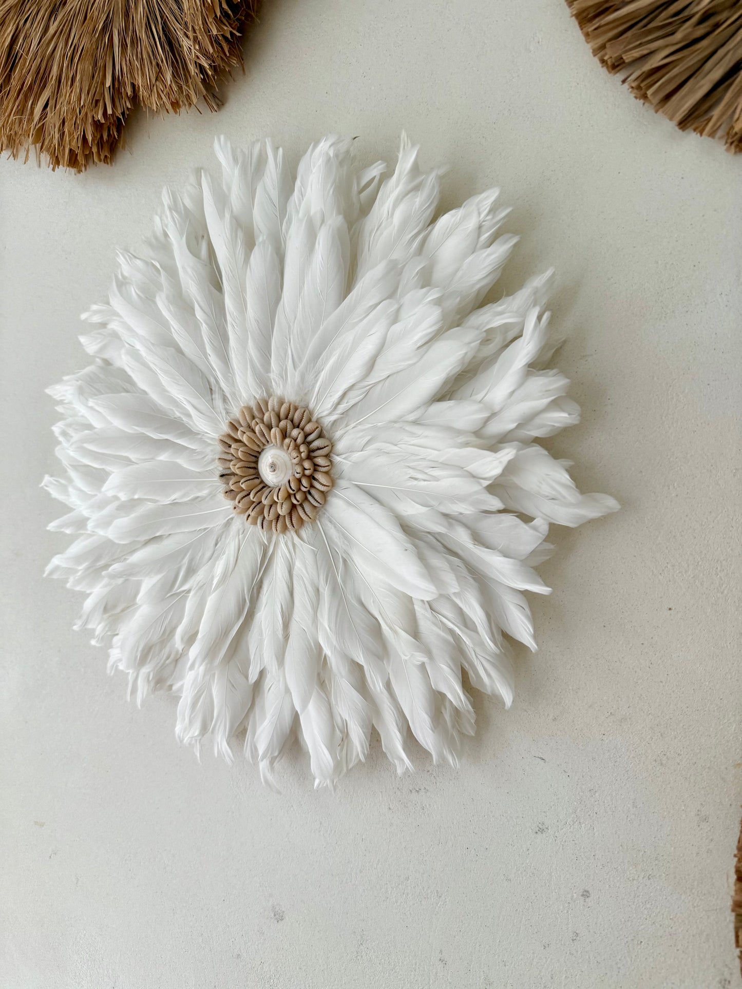 Juju Hat en plumes blanches et coquillages – décoration murale bohème et élégante